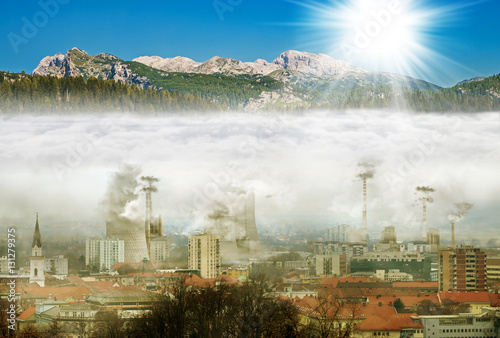 Town in smog with opposite mountains with sun