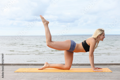 Woman doing yoga at the sea