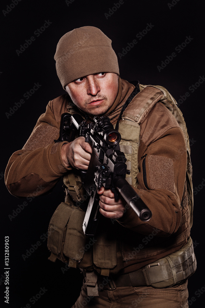Portrait soldier or private military contractor holding rifle.