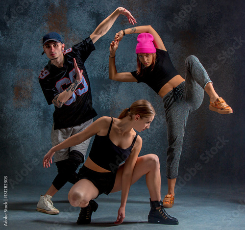 The two young girsl and boy dancing hip hop in the studio