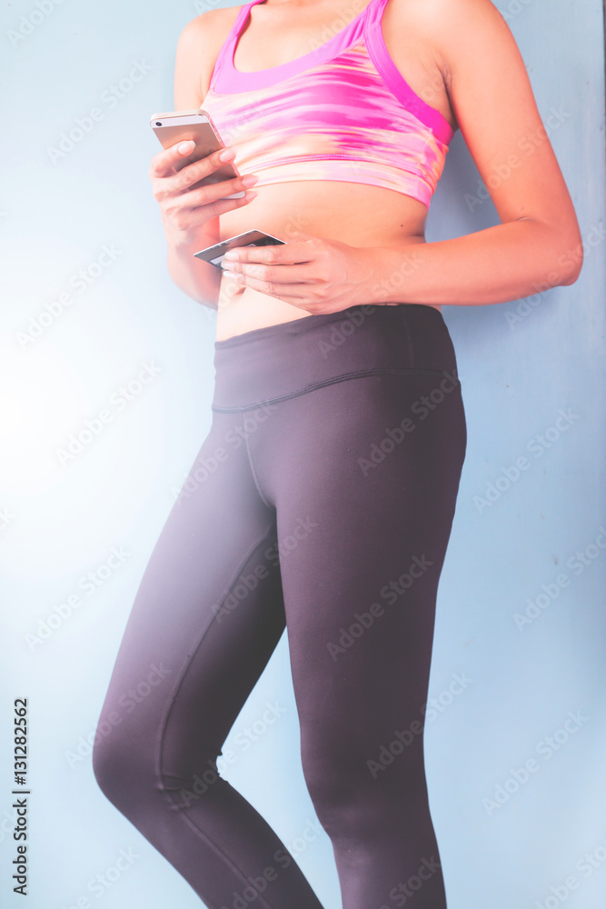 Smart phone online shopping in woman hand. Fitness clothing at sport club  background. Buy sport items with e commerce web site Stock Photo