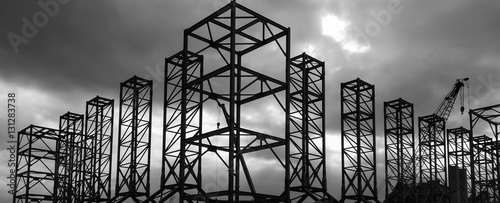 Silhouette shot of mega steel structure with crane in background. Shoot in black and white shot with dramatic sunset light.