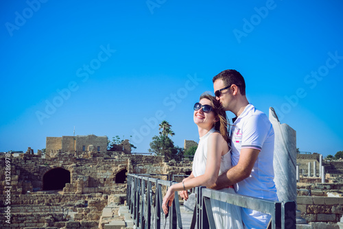 Happy romantic couple embracing each other against the background of the ruins of the ancient city