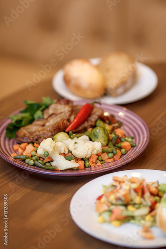 Grilled steak with vegetables and herbs on plate