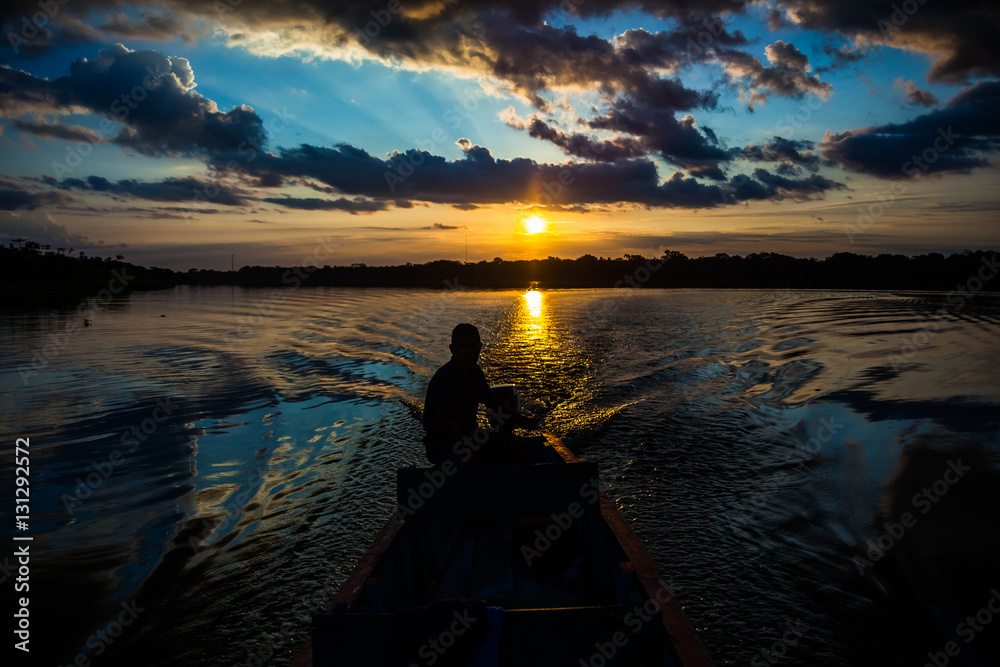 Reflection of the sun at sunset in the Limoncocha lagoon in the Ecuadorian Amazon
