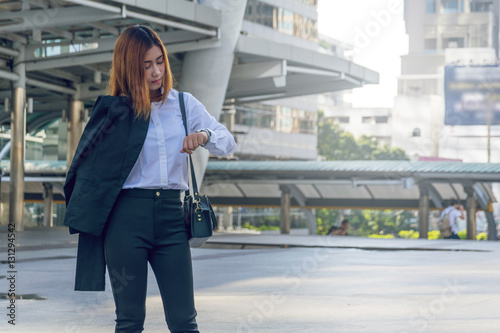 Young business woman checking the time on her watch.