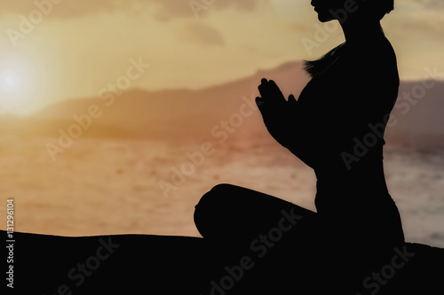 Silhouette young girl doing yoga fitness exercise outdoor in beautiful mountains landscape.