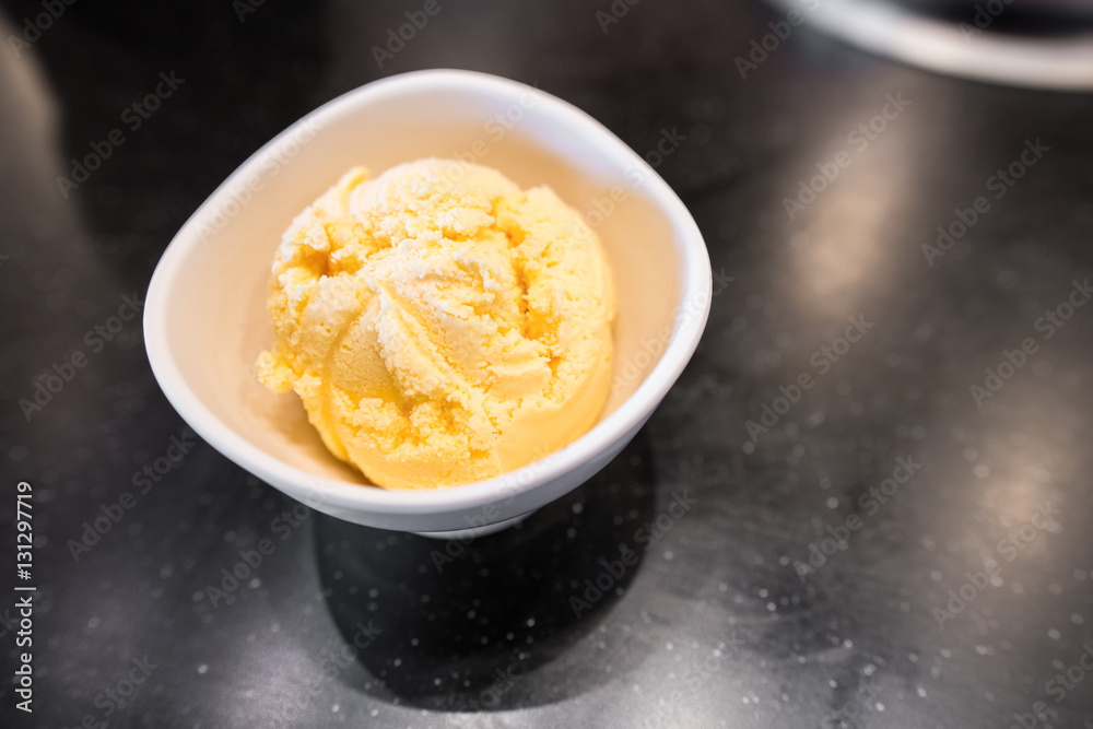 Scoop of vanilla ice cream in white bowl on black table with copy space. Scoop of vanilla ice cream in white bowl on black table with copy space.