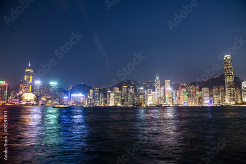    Hong Kong  China skyline panorama from across Victoria Harbor. Hong Kong city skyline view from harbor with skyscrapers buildings reflect in water at sunset
