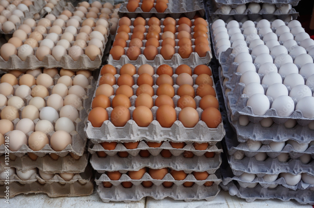 Giant cardboard crates of fresh white, yellow and brown eggs at the market
