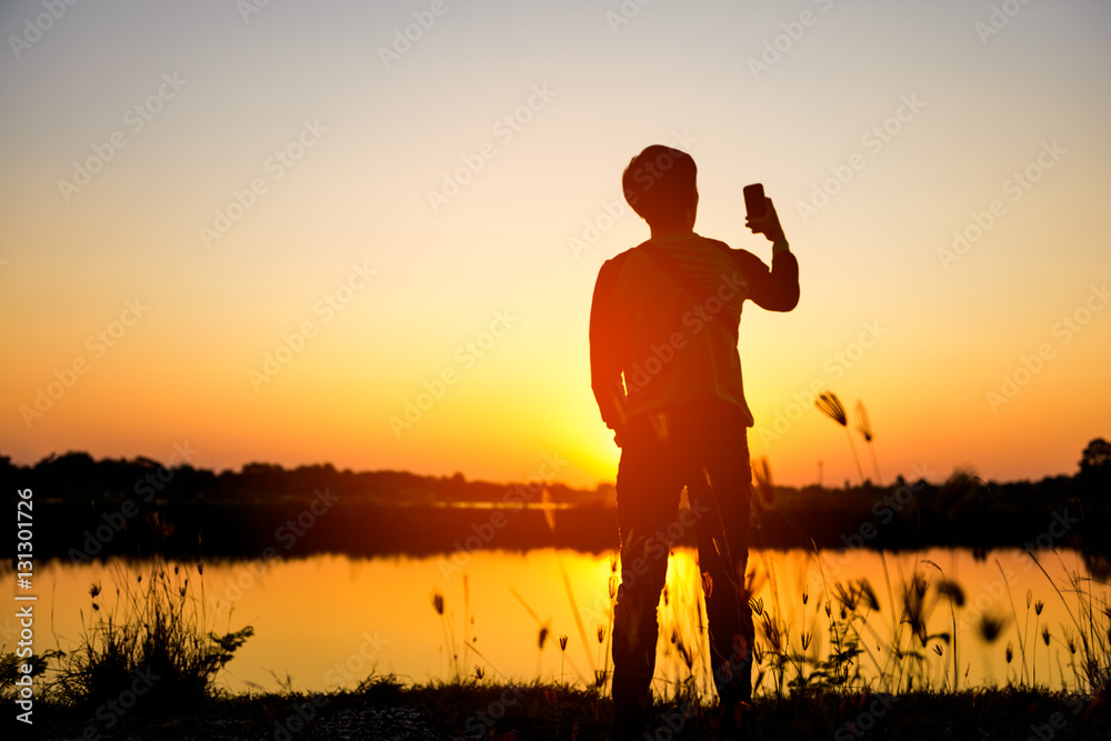 Fototapeta premium silhouette man relax on beautiful sunset background