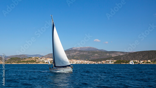 Sailboat with white sails in the Aegean sea near Greece coasts. Sailing, luxury yachts.
