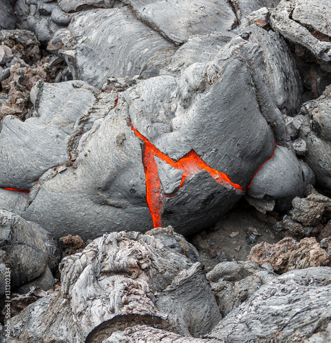 Molten lava flows on the surface of the cracks in the previously cooled lava - volcano Tolbachik, Kamchatka, Russia photo