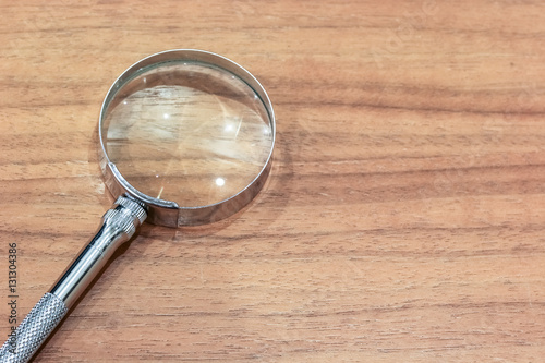 Magnifier on the wooden table with copy space