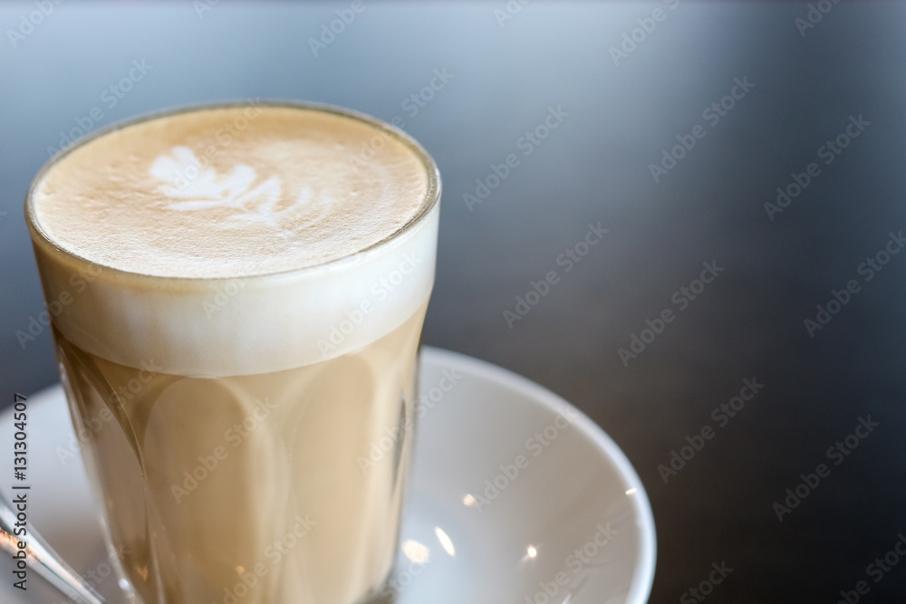 cup of the latte art coffee on the black table with copy space