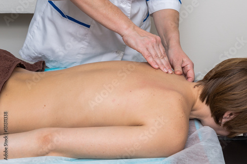 Image of a Masseuse giving  relaxing back massage