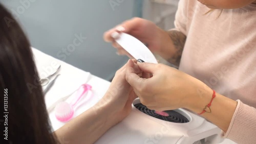 Woman manicure master doing manicure photo