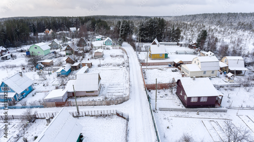 Obraz premium Russian summer cottages are covered with snow. Empty timber houses are in coniferous forest. Karelia, Russia