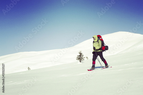 Winter hiking in the mountains on snowshoes with a backpack and