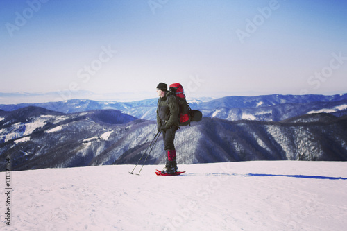 Winter hiking in the mountains on snowshoes with a backpack and