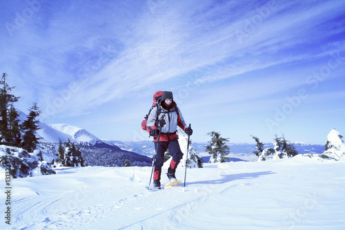 Winter hiking in the mountains on snowshoes with a backpack and