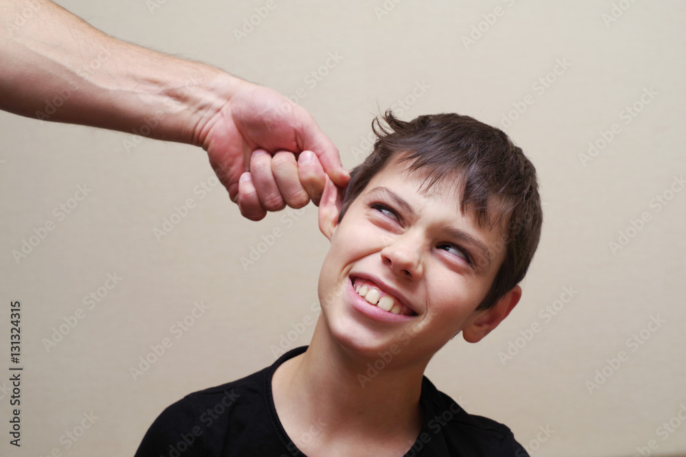 Boy receives physical punishment from the adult. Have grabbed by an ear. Boy receives physical punishment from the adult. Have grabbed by an ear.