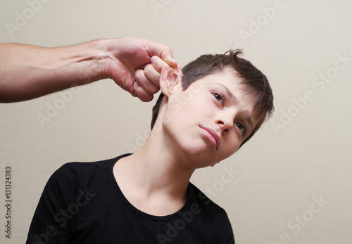 Boy receives physical punishment from the adult. Have grabbed by an ear.