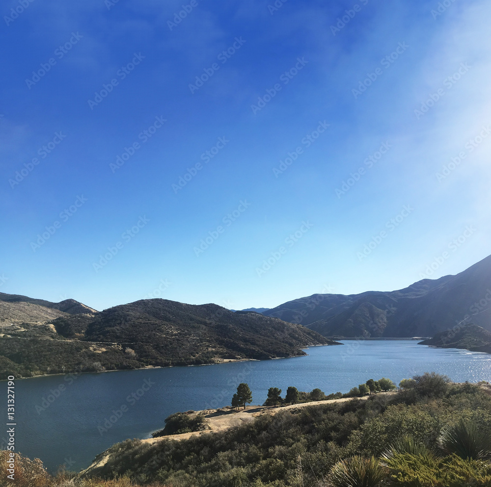 Pyramid Lake with hills on a blue sky
