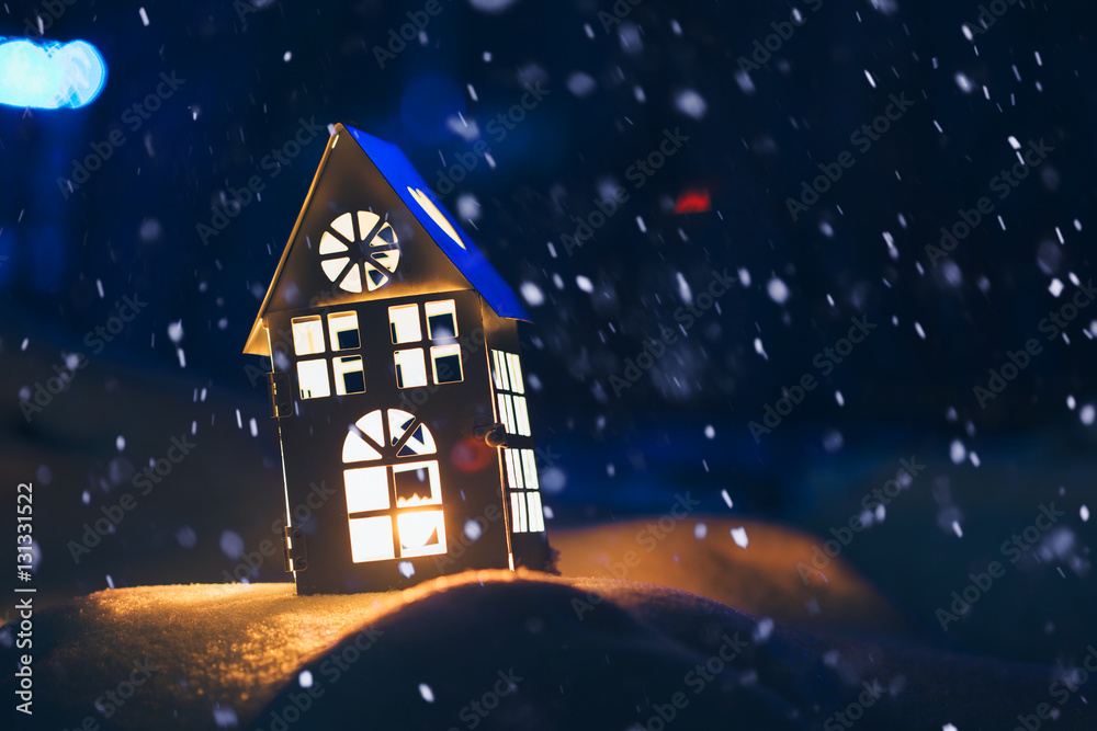 Fototapeta premium Lantern house with burning candle on snow in the evening