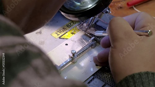 White man repairing broken smartphone iphone in workshop. Preparing motherboard to replace chip