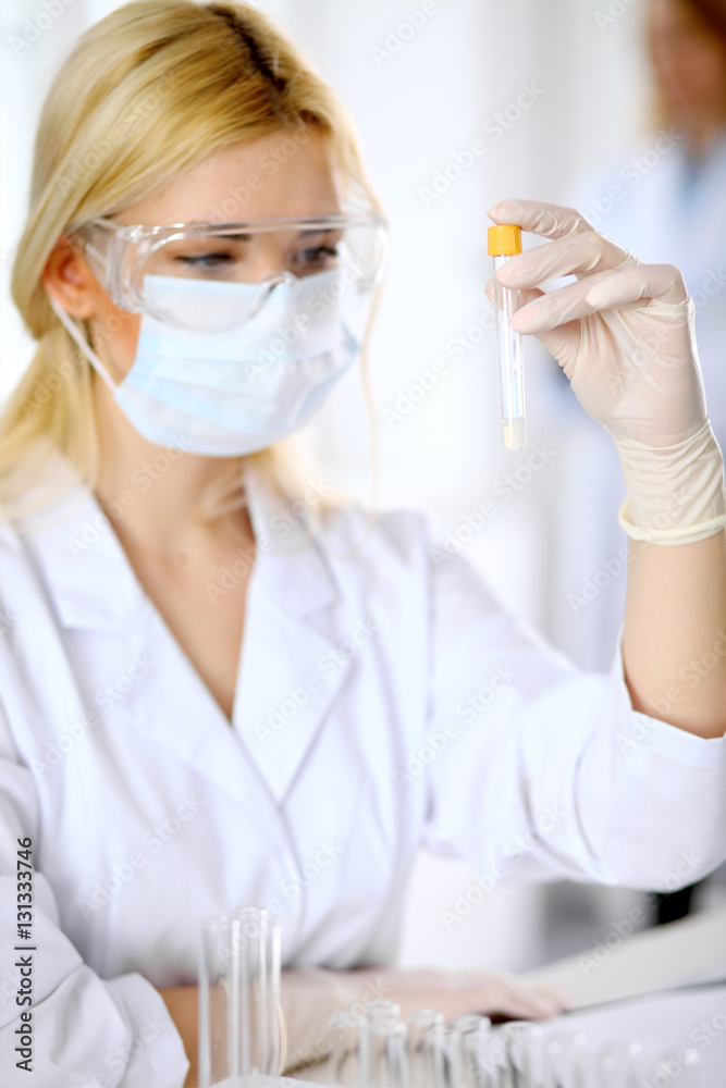 Female scientific research team with clear solution in laboratory. Medicine and health care concept Female scientific research team with clear solution in laboratory. Medicine and health care concept
