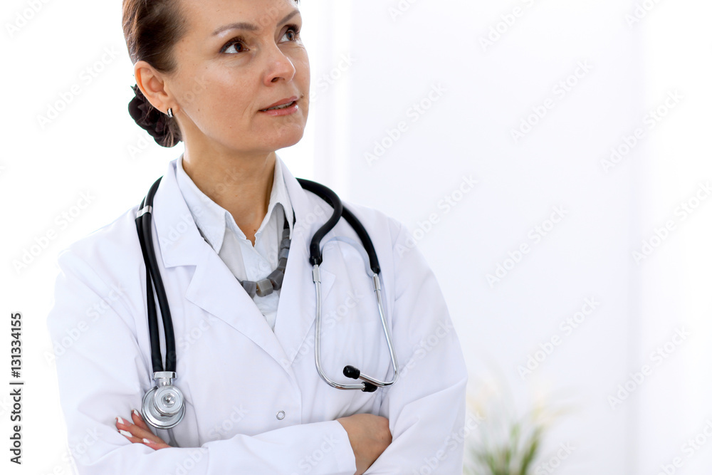 Happy female doctor standing in hospital. Medicine and health care concept. Happy female doctor standing in hospital. Medicine and health care concept.