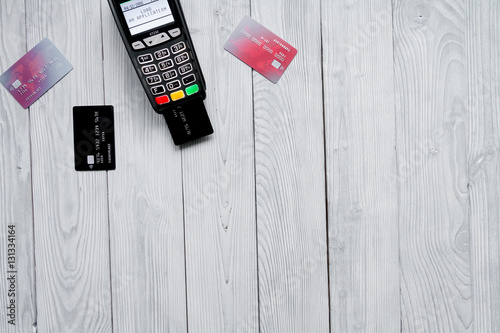 payment card through terminal in store top view wooden background