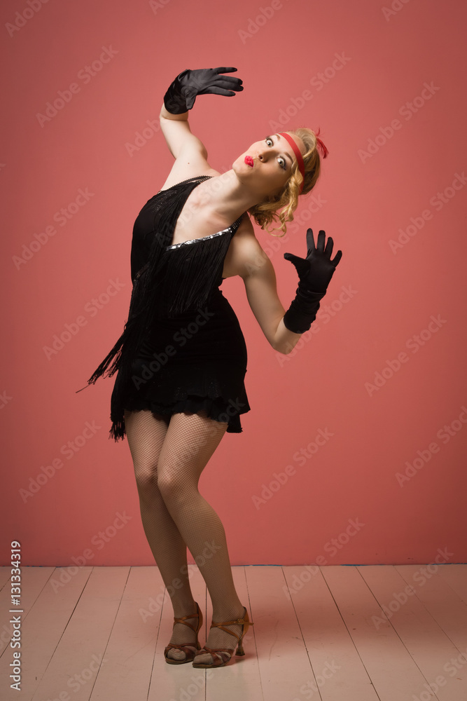 Pretty actress in black retro dress dancing charleston Photos | Adobe Stock