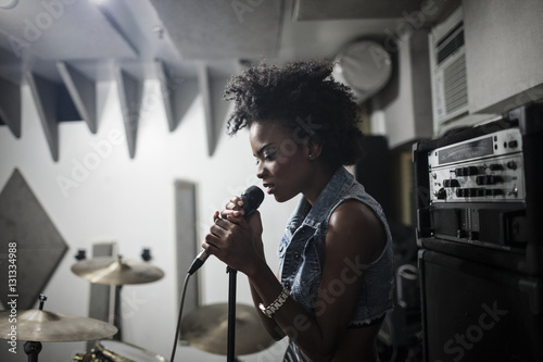 Young female singer performing in studio