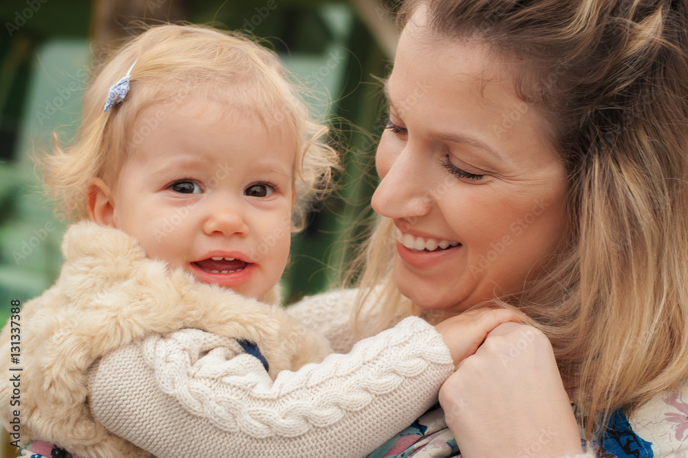 Obraz premium Young mother having her little daughter in baby carrier scarf