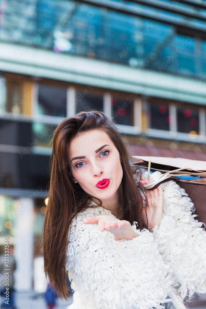 Obraz premium Portrait of beautiful young brunette woman with shopping bags outdoors