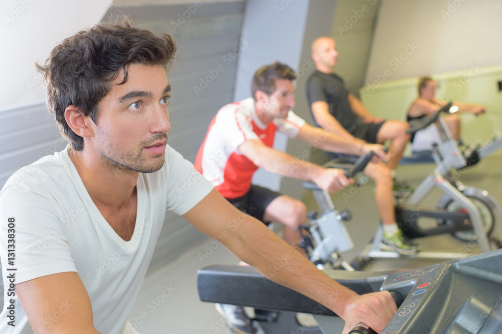 Men on exercise bikes Men on exercise bikes