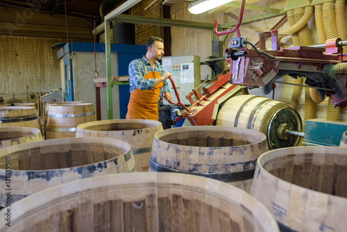 wood barrels production cooper using hammer and tools in workshop