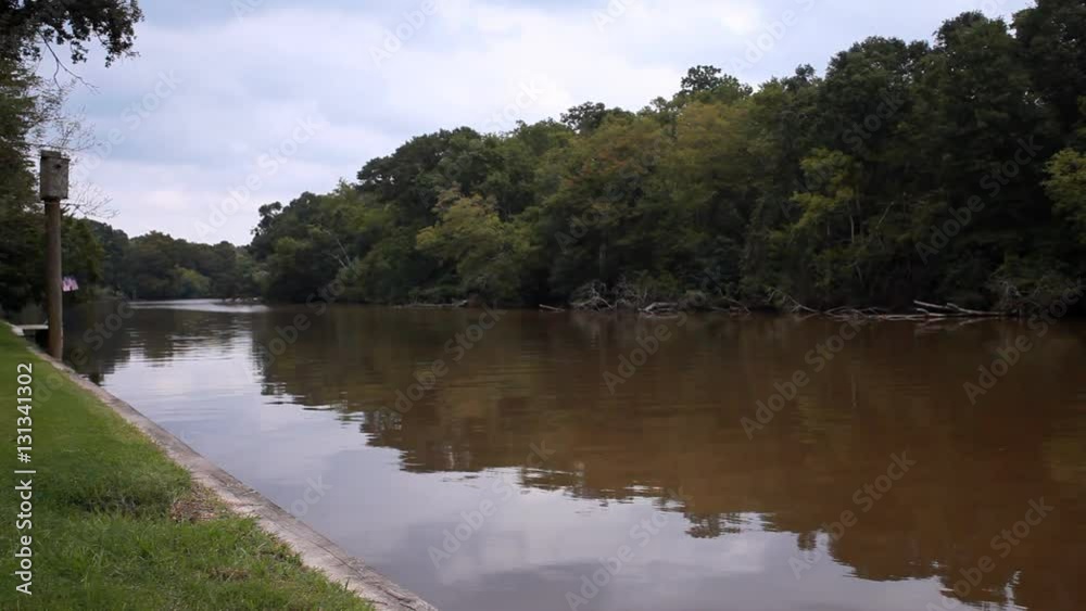 calm muddy waters of a small winding river with heavily wooded banks. calm muddy waters of a small winding river with heavily wooded banks.