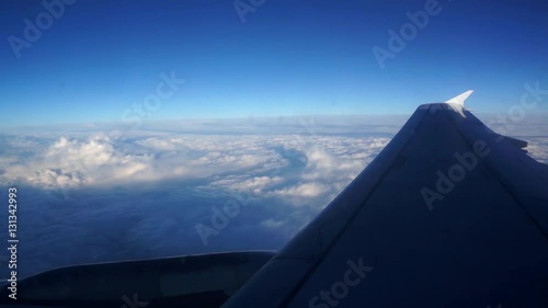 The wing of the aircraft above the clouds