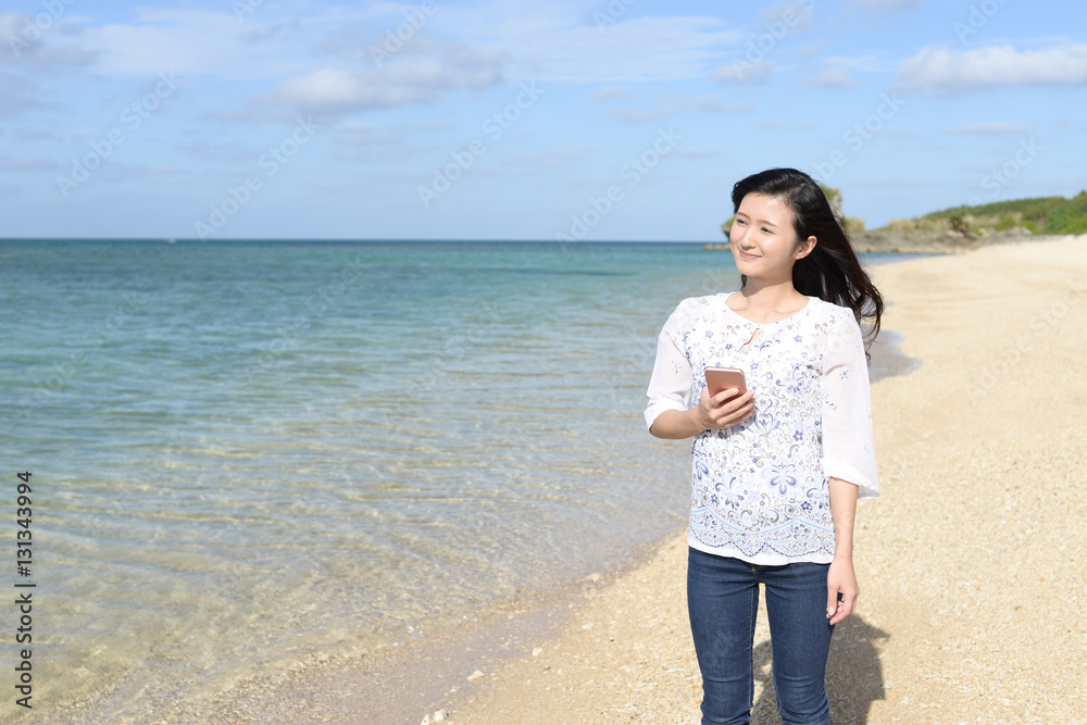 南国沖縄の美しいビーチで寛ぐ女性