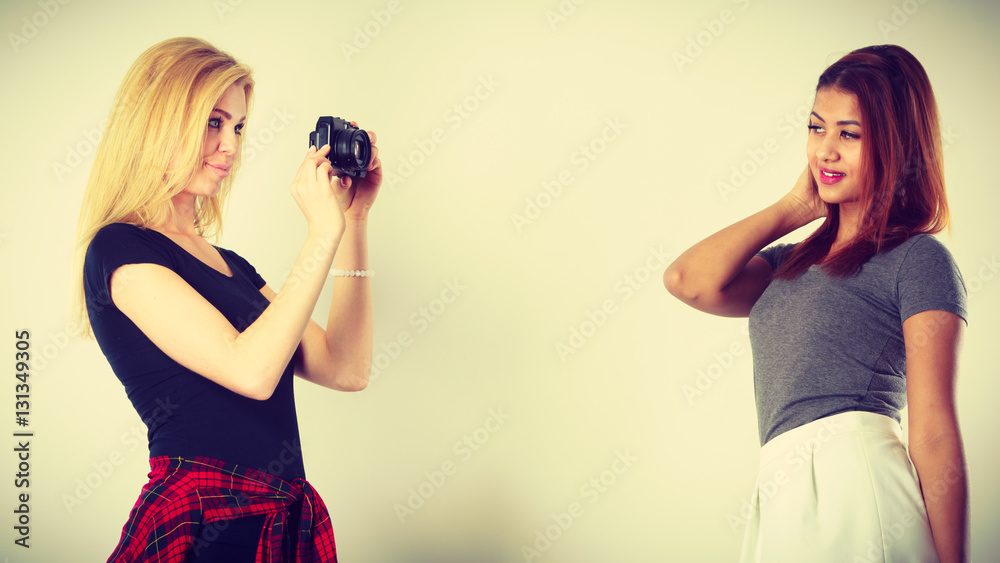 Blonde girl photographing woman