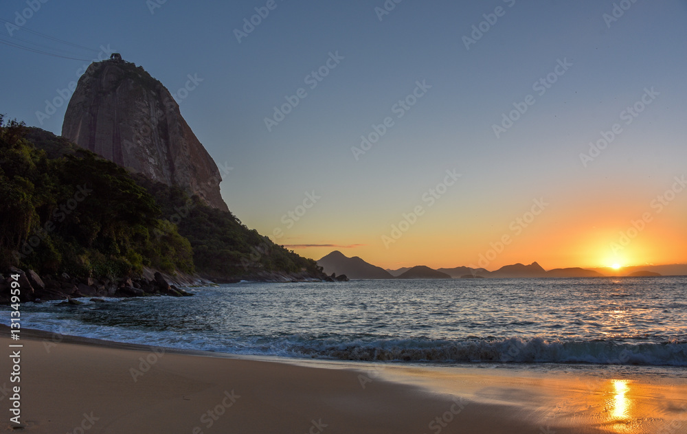 Beautiful sunrise at Praia Vermelha Beach, the sun rising from the Atlantic Ocean and the Sugarloaf Mountain, Rio de Janeiro, Brazil