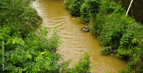 A brown coloured dirty river in Bogor indonesia photo