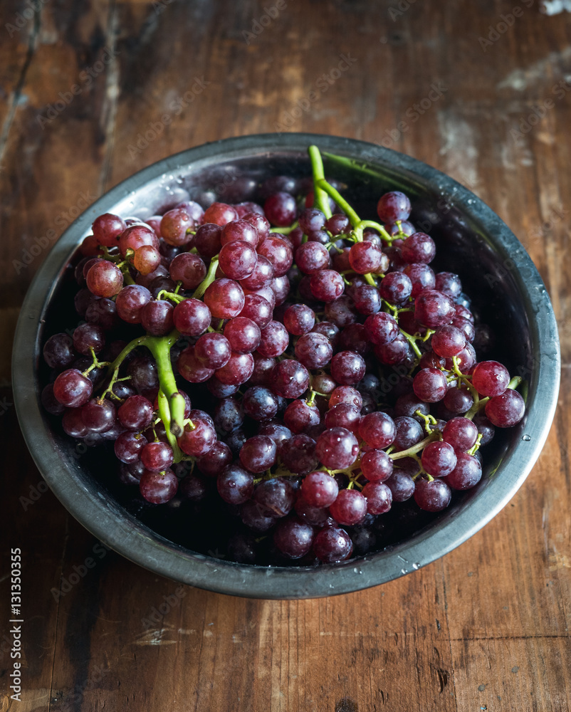 Red wine Grapes in a bowl on wood background Red wine Grapes in a bowl on wood background