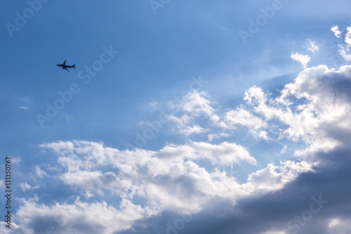 Small plane in blue sky with clouds background