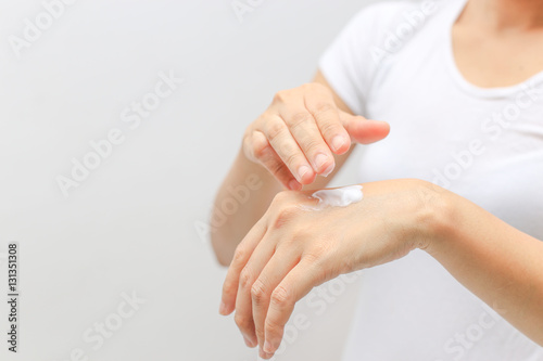 closeup female applying cream on her hand