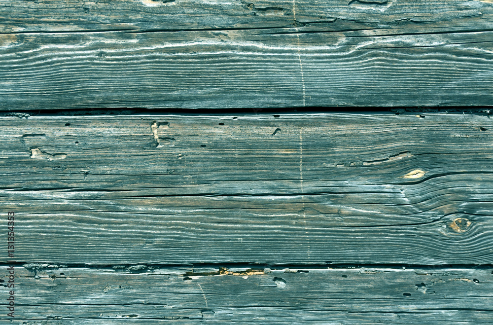 Cyan toned weathered log house surface.