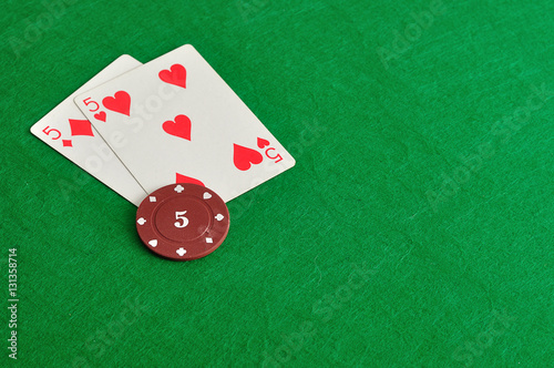 Two cards with a poker chip with the value of five 